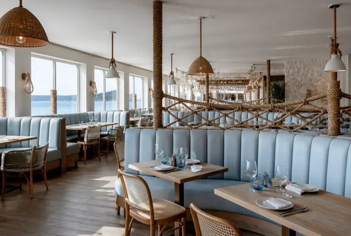 Coastal seafood dining room with pale wood, wide windows and a chilled raw bar counter