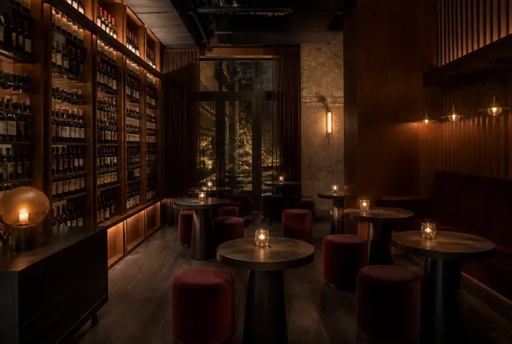 Wine bar dining room with high tops, a tasting counter and floor to ceiling bottle storage